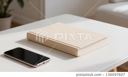 Minimalist concept of choice between analog and digital, hardcover book and smartphone on white table in cozy modern interior 136097607