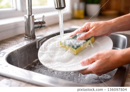 Washing Dishes by Hand in Kitchen Sink with Sponge and Soap Foam 136097804