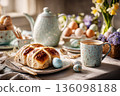 A brunch table is set for Easter with pastel tableware, colorful decorated eggs, spring flowers, and hot cross buns. Friends and family gather to celebrate this holiday together 136098188