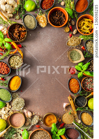 A colorful assortment of fragrant herbs and spices on a warm brown background, showcasing their visual variety and aromatic appeal, spice frame A colorful assortment of fragrant herbs and spices on a warm brown background, showcasing their visual variety and aromatic appeal, spice frame 136098285