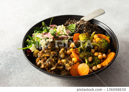 A nutritious breakfast bowl with black quinoa, avocado, roasted chicken, sweet potatoes, zucchini, and broccoli, paired with a fresh salad of cabbage, radish, chia, and sesame seeds A nutritious breakfast bowl with black quinoa, avocado, roasted chicken, sweet potatoes, zucchini, and broccoli, paired with a fresh salad of cabbage, radish, chia, and sesame seeds 136098630