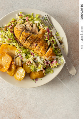 Fresh baked potatoes and chicken breast served with a salad of Chinese cabbage and pink radish make a healthy breakfast option. This meal is prepared at home and offers nutrition 136098640