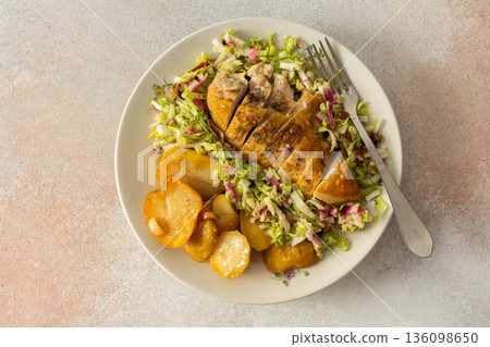 Fresh baked potatoes and chicken breast served with a salad of Chinese cabbage and pink radish make a healthy breakfast option. This meal is prepared at home and offers nutrition Fresh baked potatoes and chicken breast served with a salad of Chinese cabbage and pink radish make a healthy breakfast option. This meal is prepared at home and offers nutrition 136098650