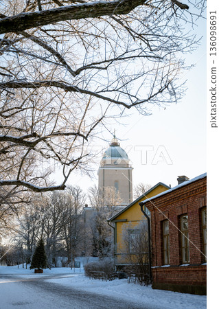 Helsinki Cathedral tower in snowy winter city park with historic buildings and frosty trees 136098691