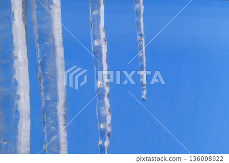 Icicles hanging from the roof in Morioka City, Iwate Prefecture. The blue winter sky and melting icicles signal spring is near. 136098922