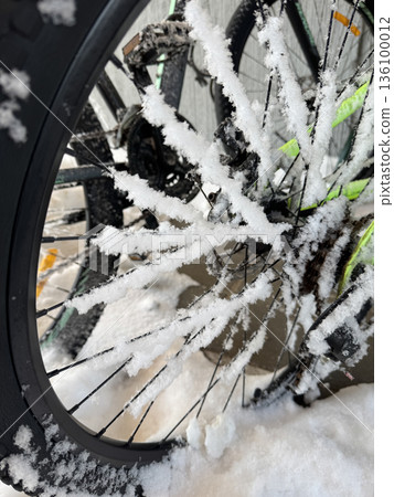 Rear bicycle wheel in the snow. Spokes covered with snow. Close-up. Winter landscape. Rear bicycle wheel in the snow. Spokes covered with snow. Close-up. Winter landscape. 136100012