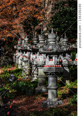 Symbol of determination, good luck charm in Japanese, Many traditional red Daruma doll on stone lantern at Katsuo-ji temple, Osaka, Japan. 136100280