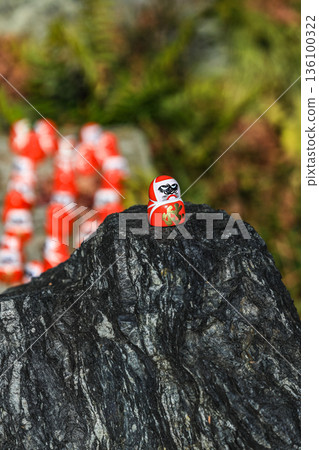 Symbol of determination, good luck charm in Japanese, Many traditional red Daruma doll on the rock at Katsuo-ji temple, Osaka, Japan. 136100322