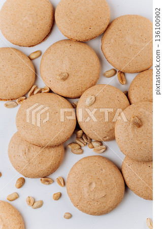 Peanut macarons flat lay on white background, minimal sweet dessert Peanut macarons flat lay on white background, minimal sweet dessert 136100902