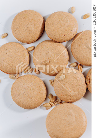 Peanut macarons flat lay on white background, minimal sweet dessert Peanut macarons flat lay on white background, minimal sweet dessert 136100907