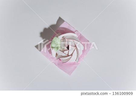 Meringue swirl dessert on pink parchment, minimal flat lay with hard shadow Meringue swirl dessert on pink parchment, minimal flat lay with hard shadow 136100909