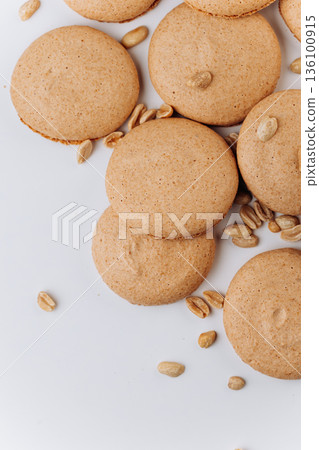 Peanut macarons flat lay on white background, minimal dessert texture Peanut macarons flat lay on white background, minimal dessert texture 136100915