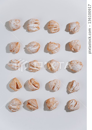 Powdered sugar pastries pattern on white background, flat lay Powdered sugar pastries pattern on white background, flat lay 136100917