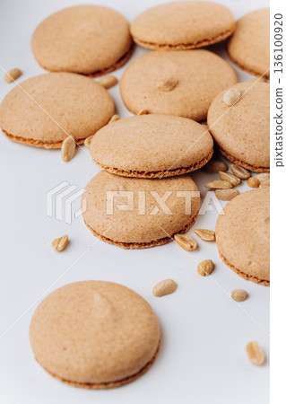 Peanut macarons flat lay on white background, minimal sweet dessert Peanut macarons flat lay on white background, minimal sweet dessert 136100920