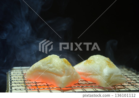 Grilling mochi on a charcoal grill with smoke rising Grilling mochi on a charcoal grill with smoke rising 136101112