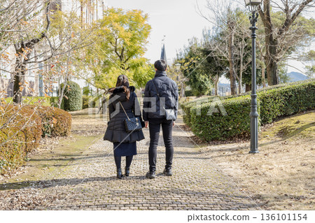 Parent and child walking in autumn park 136101154