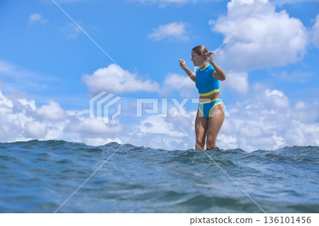 Energetic Female Surfer Demonstrates Control In Dynamic Summer Training Session 136101456