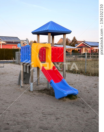 A brightly colored children's slide on a sand playground A brightly colored children's slide on a sand playground 136102150