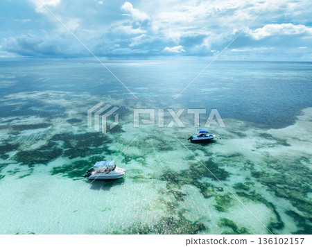 Aerial view of two motorboats anchored in clear turquoise water Aerial view of two motorboats anchored in clear turquoise water 136102157