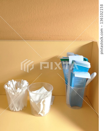 Cotton swabs, wipes and spatulas in plastic cups on a shelf Cotton swabs, wipes and spatulas in plastic cups on a shelf 136102158