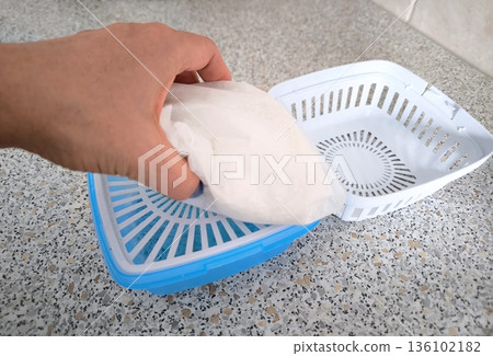 The process of replacing a cartridge in a household dehumidifier, top view The process of replacing a cartridge in a household dehumidifier, top view 136102182