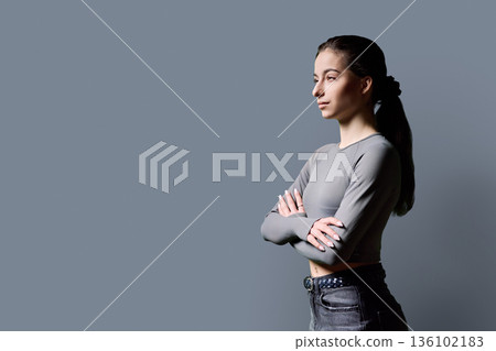 Portrait of beautiful serious young woman, 18-19 years old on gray background Portrait of beautiful serious young woman, 18-19 years old on gray background 136102183