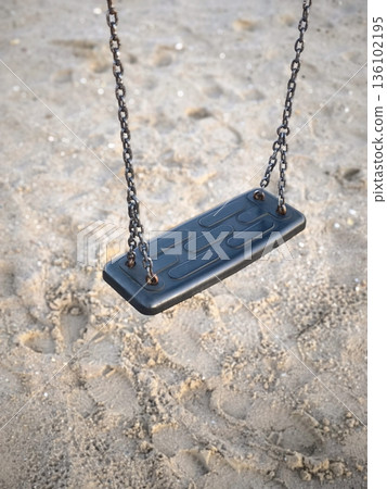 A single black swing on chains at a sand playground A single black swing on chains at a sand playground 136102195