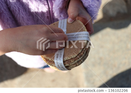 A girl feeding deer crackers sold in Nara Park A girl feeding deer crackers sold in Nara Park 136102206