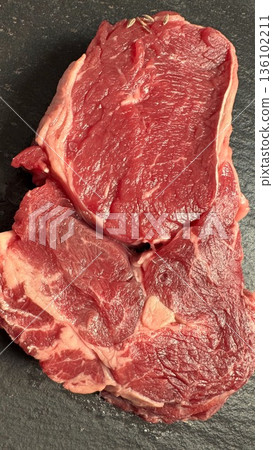 Fresh Meat Highlight, Gourmet Preparation Of Fresh Ribeye Steak Under Studio Lighting, Highquality Ribeye Beef With Marbling Showcased On Black Slate For Gourmet Presentation 136102211