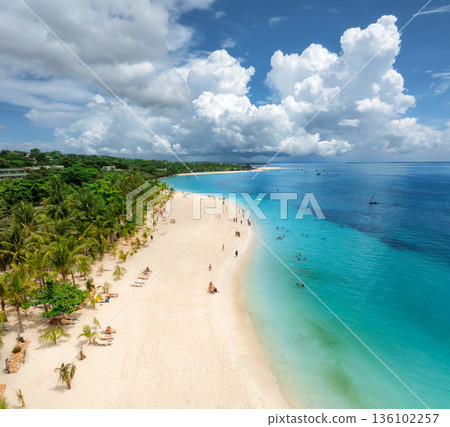 Aerial view of tropical sandy beach, blue sea and rain clouds 136102257