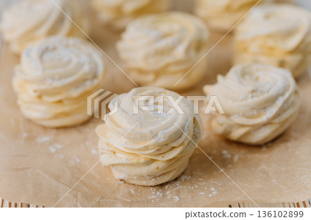 Vanilla zephyr marshmallow rosettes on parchment, soft pastel closeup Vanilla zephyr marshmallow rosettes on parchment, soft pastel closeup 136102899