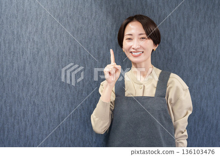 一位穿著圍裙的女店員指著 136103476