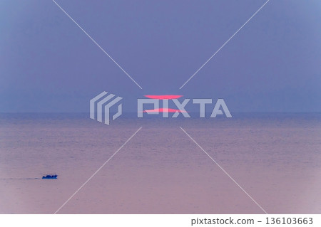 A mirage on the horizon and a fantastic sunset. A phantom sun and a quiet seascape. 136103663