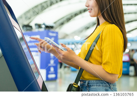 A woman operates a kiosk. Photo courtesy of Kansai International Airport (KIX). 136103765