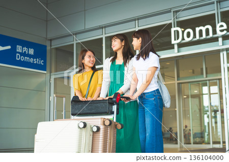 Three women carrying luggage at the airport. Photo courtesy of Kansai International Airport (KIX). 136104000