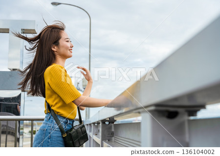 A woman's smile fluttering in the wind ■Photography cooperation: Kansai International Airport (KIX) 136104002