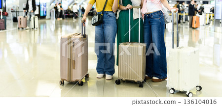 Three people carrying suitcases at the airport ■Photography cooperation: Kansai International Airport (KIX) 136104016