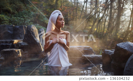 A young Japanese woman relaxing in an open-air bath. Image of hot spring travel and beautiful skin. 136104232