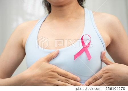 Breast cancer, pink ribbon at Asian senior lady for supporting awareness, symbol of World Breast Cancer Day. 136104278