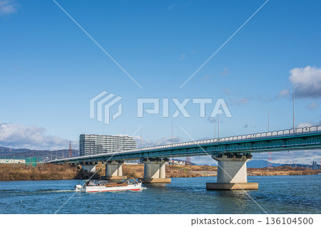 Hirakata Bridge over the Yodo River. Gravel mining boats sailing upstream. View from the Hirakata City side. Hirakata Bridge over the Yodo River. Gravel mining boats sailing upstream. View from the Hirakata City side. 136104500