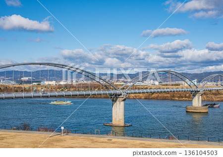 A water pipe bridge over the Yodo River. A gravel mining boat sailing upstream. A view from the Hirakata City side. 136104503