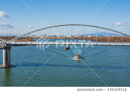 A water pipe bridge over the Yodo River. A gravel collection boat sailing upstream. A view from Hirakata Bridge. A water pipe bridge over the Yodo River. A gravel collection boat sailing upstream. A view from Hirakata Bridge. 136104516