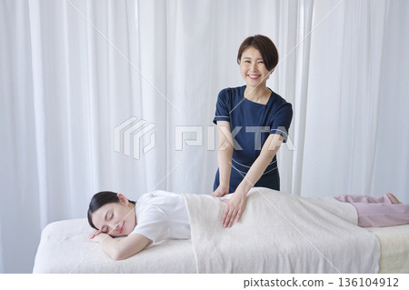 女按摩師做背部按摩的肖像 136104912