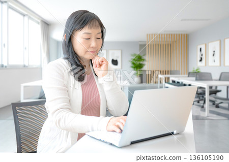 A woman thinking while looking at a PC 136105190