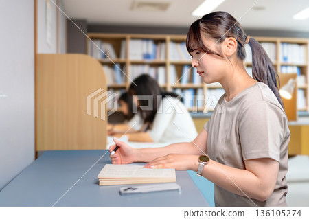 A woman studying 136105274