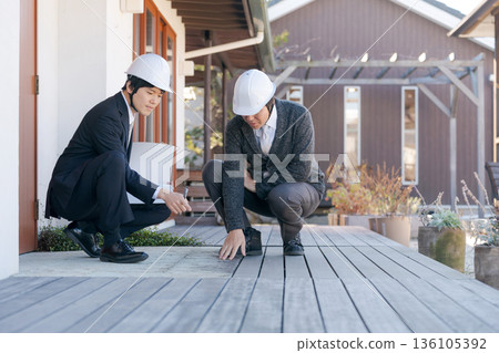 A man inspecting a wooden deck A man inspecting a wooden deck 136105392