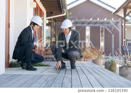 A man inspecting a wooden deck A man inspecting a wooden deck 136105395