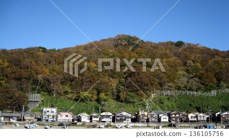 A view of a fishing village with blue skies and autumn leaves on the mountains A view of a fishing village with blue skies and autumn leaves on the mountains 136105756