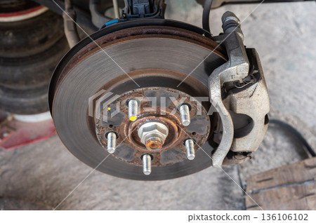 Close up of a car wheel and disc brake while waiting for repair in garage. 136106102