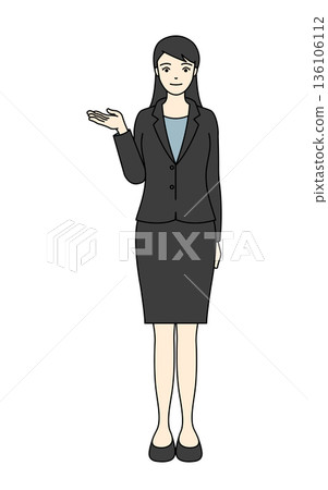 一位身穿黑色西裝的女士正在做演示或下達指示，右手伸出。 136106112